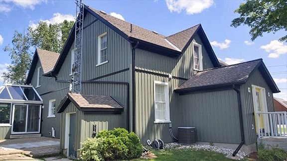 Dark grey board and batten home with sunroom